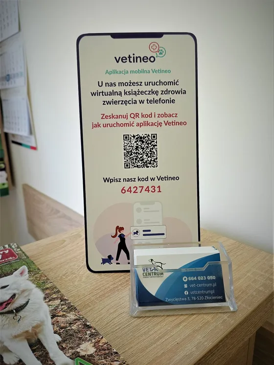 Stojak z instrukcją aplikacji Vetineo i kodem gabinetu 6427431 w poczekalni Vet Centrum, obok wizytówki gabinetu